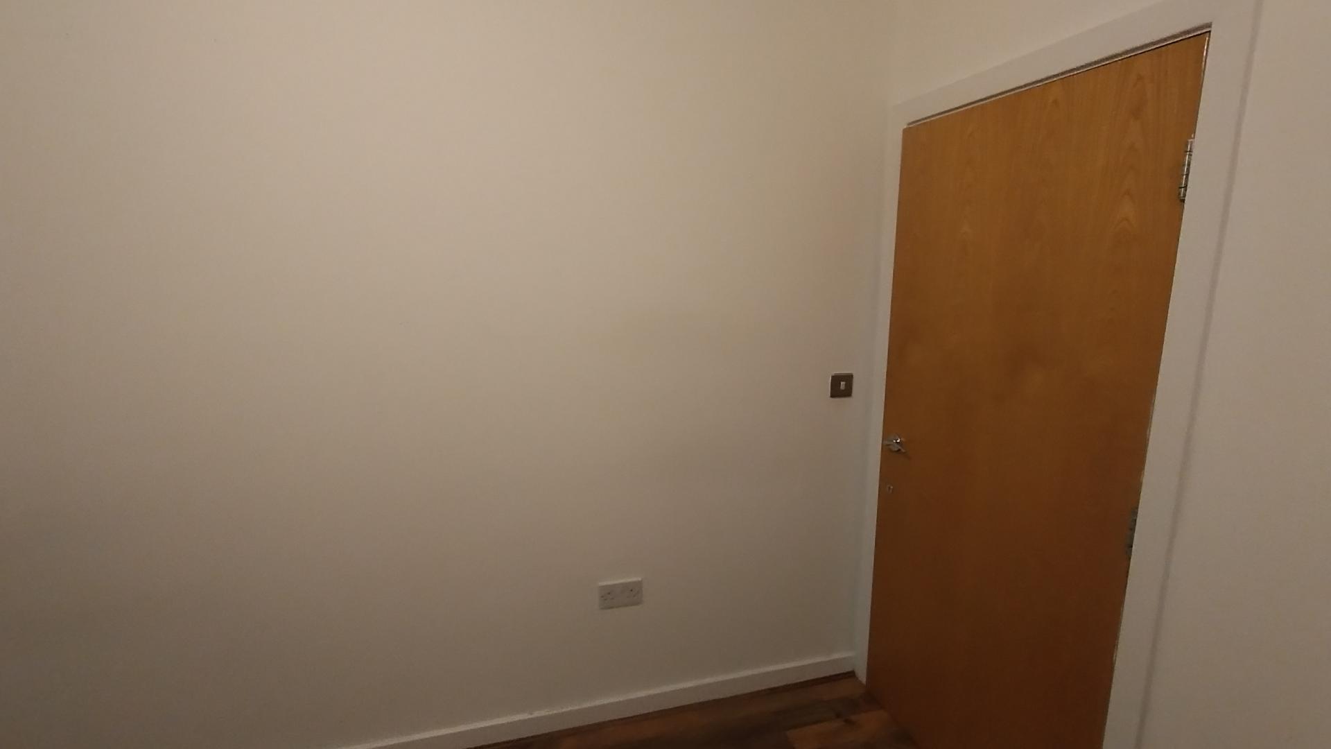 a photo of rebecca's bedroom, demonstrating a large and featureless blank wall